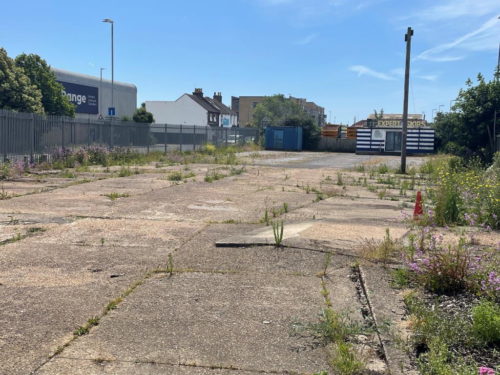 Lot: 99 - LAND WITH RESIDENTIAL PLANNING FOR 33 UNITS - View of site from north showing prefab buildings